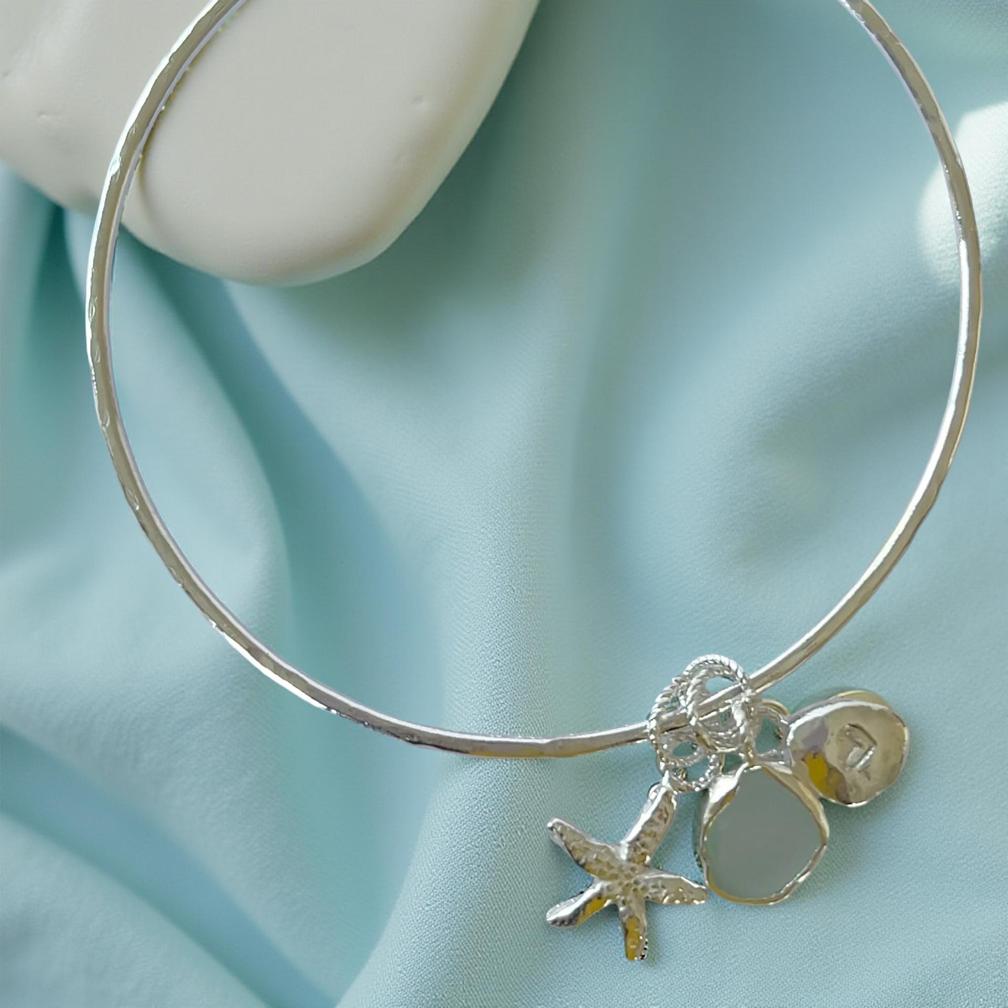 Silver bracelet with starfish and sea glass charm on a wooden surface - SilverLines Jewellery