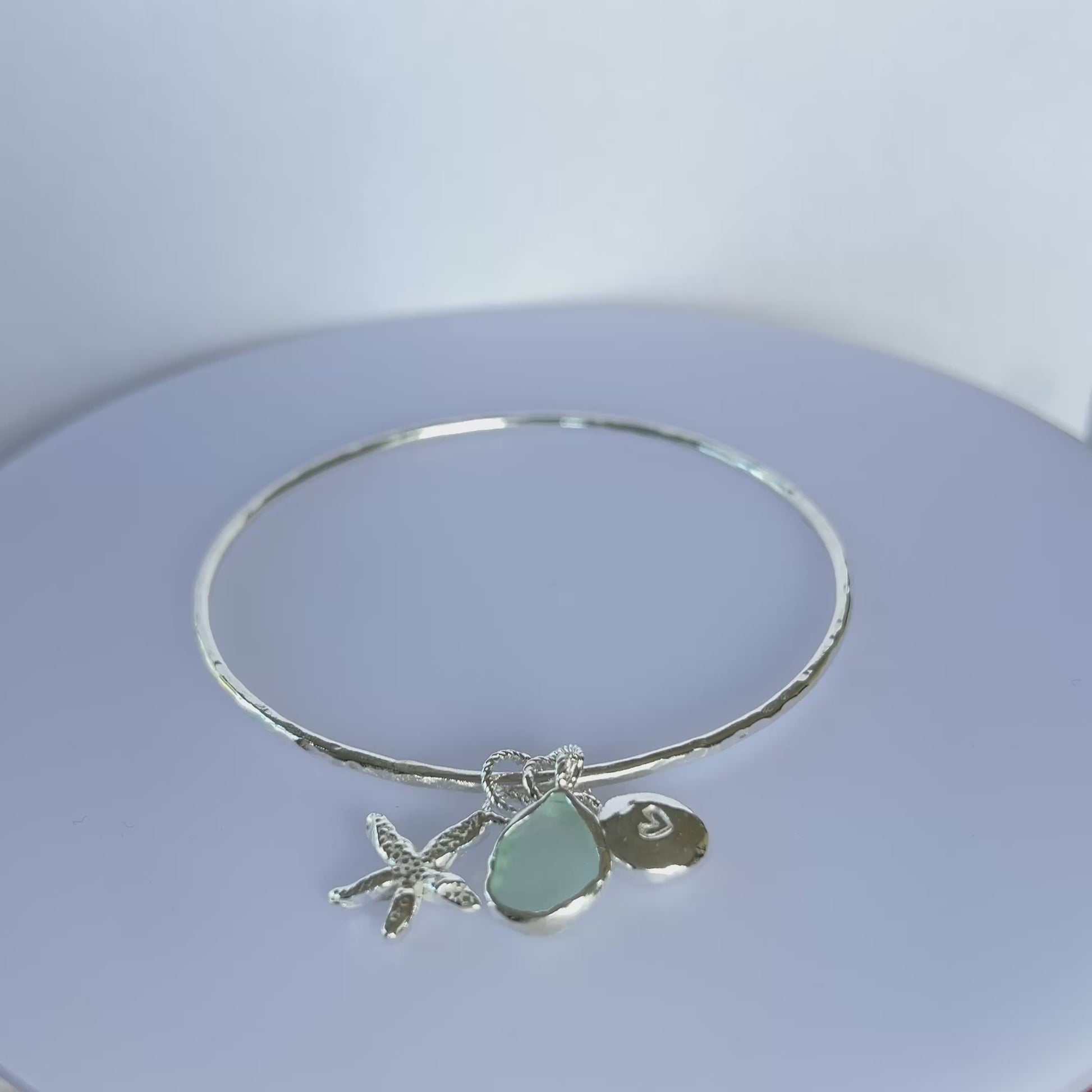 Silver bracelet with starfish and sea glass charm on a wooden surface - SilverLines Jewellery